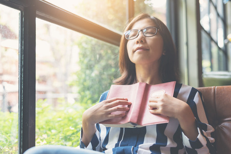 Relaxed Asian Woman holding a book. Happiness, copy space.の写真素材