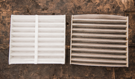 Close up used and new air filter of car on dirt background.の写真素材