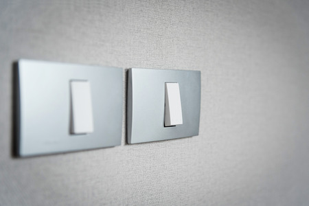 Close up grey light switches on texture background. Copy space.