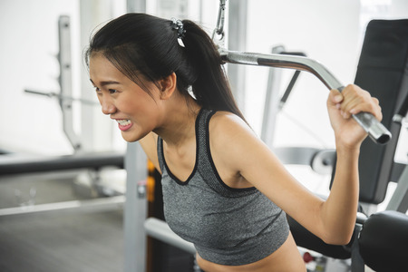 Asian woman in sportswear exercising with exercise machine at the gym.の写真素材