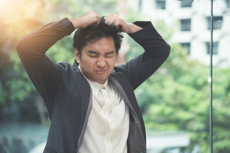 Frustrated Asian Businessman failing about his business. Stress, tired concept.の写真素材
