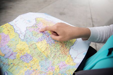 Tourist planning on vacation. Close up woman hand on the map.の写真素材
