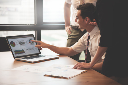 Young businessman discussing to business people with laptop. Brainstorming and meeting at the office.の写真素材