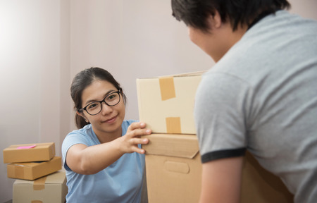Young people checking cardboard boxes in their small warehouse. Own business.の写真素材