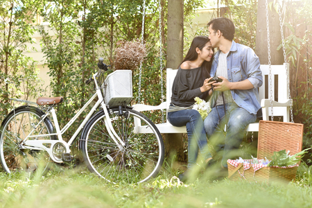 Romantic Asian couple in love and kissing at the park.の写真素材
