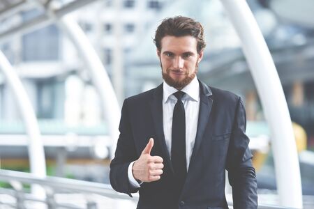 Portrait of confident Handsome Businessman showing thumb up and looking at the camera. Copy space.