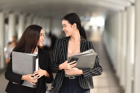 Young Asian Business  women walking and talking at office corridor. Copy space.の写真素材