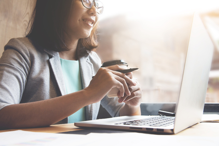 Close up of Business woman holding cup of coffee and relaxing with smiling face.の写真素材