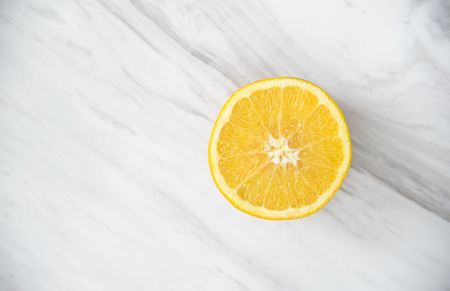 Top view. Sliced orange and glass of orange juice on white marble. Copy space. Diet healthy.の写真素材