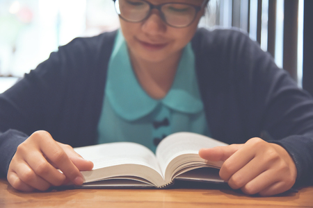 Close up Woman reading book or diary on wooden table. Copy space.の写真素材