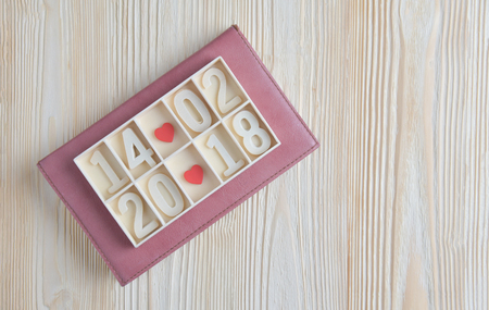 Valentines day. Wooden block calendar show date, month and year with Two Red hearts on vertical wood...