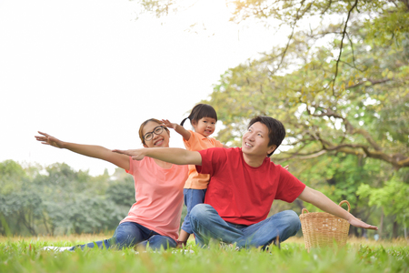Happy young Asian family with their daughter having fun in nature at park outdoor.の写真素材