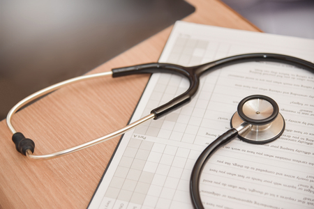 Close up Stethoscope and clipboard on wooden desk. Healthcare and medical concept.の写真素材