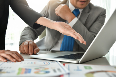 Businessman in grey suit are discussing with Businesswoman at meeting. Business Chart or graph document and laptop.の写真素材