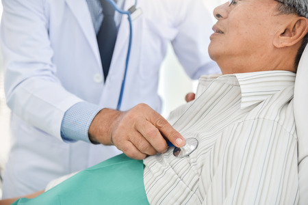 Senior Doctor is examining An Asian senior patient with stethoscope on a bed at the hospital. Medical and health care concepts.の写真素材