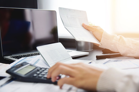 Close up of woman hand calculating her monthly expenses with calculator.  Debt. Bank account.