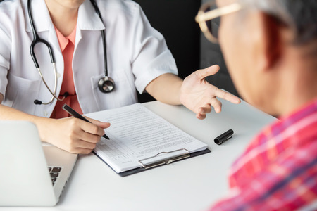 Young Asian Female Doctor consulting with senior man patient in medical room.の写真素材
