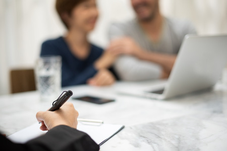 Focus on hand. Young man and woman planning with professional consultant. Couple holding hands together.の写真素材