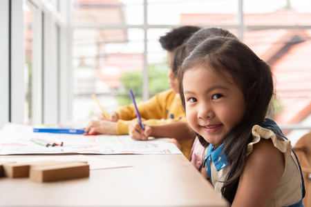 Portrait Asian Little girl with Smiling face in a classroom at a school. Looking at camera. Copy space.の写真素材