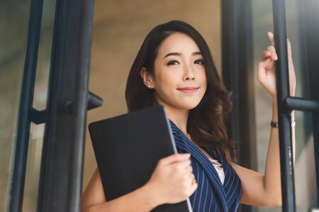 Successful of Young female is standing at front of the office. Pretty Asian female is smiling and...
