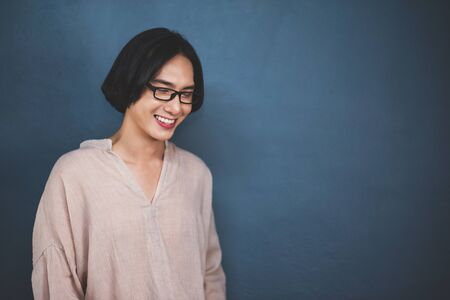 Portrait of Asian wear eyeglasses smiling man in glasses over blue background