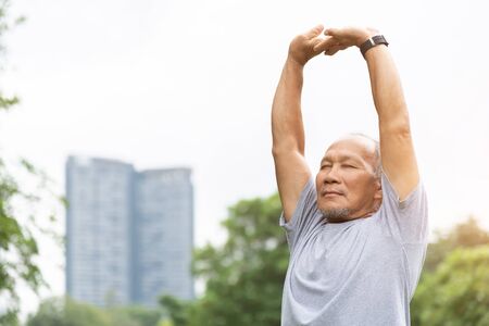 Asian senior man stretching his arms in the air before exercising. Copy space.の写真素材
