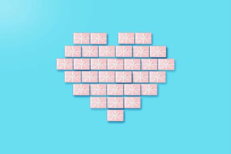 Creative Heart shape by pink gift boxes on blue background. Valentine's day concept.の写真素材