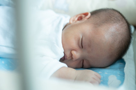 Close Up of Asian Newborn baby boy sleeping in the bed. Motherhood and New life.