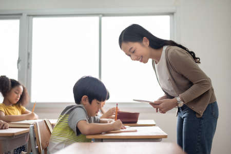Asian Young Teacher teaching her diverse Multi Ethnic students in classroom at international school.の写真素材