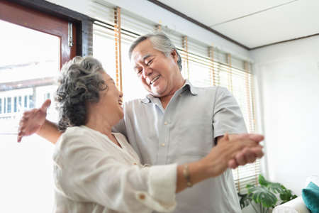 Romantic Asian Grandfather and Grandmother dancing at home together.の写真素材