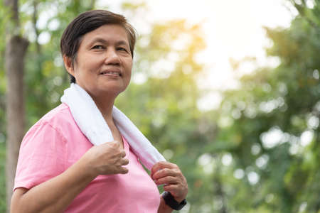 Portrait of Asian smiling sporty senior woman in a park outdoor.の写真素材