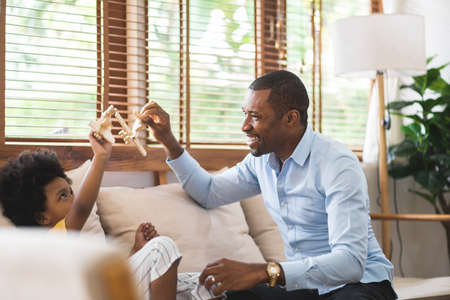 African American Father and little boy playing airplane toys at home together, Happy Black family, Single Dad, Father'day.の写真素材