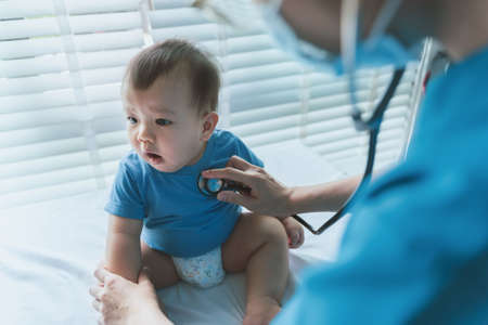 Asian Pediatrician with patient baby at pediatric clinic, Doctor using stethoscope for checking heart beat and lungs, Medical examの写真素材