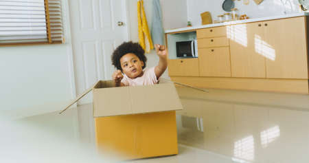 African American Afro Boy playing with carton car indoors at home.の写真素材