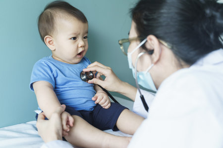 Asian female Doctor using stethoscope for checking heart beat and lungs with patient baby boy, Medical examの写真素材