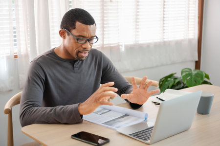 Black African American man having online video conference with laptop in a meeting at home office, Video call, Freelancer, Entrepreneurの写真素材