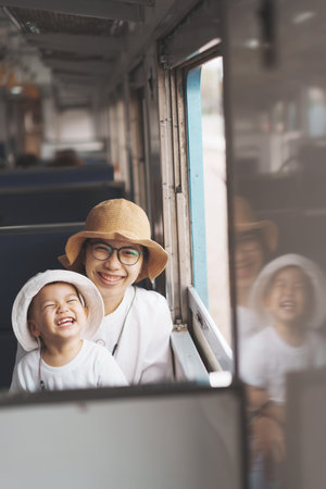 Portrait Of Happy Laughing Asian little boy and mother traveling by train, Playful Child with big smile.の写真素材