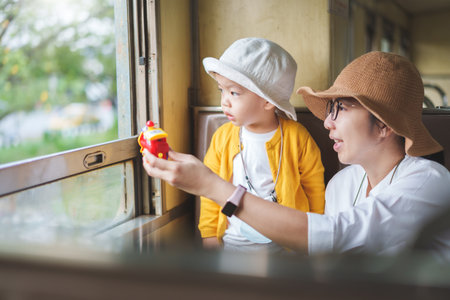Asian mother and little child boy traveling by train on holiday togetherの写真素材