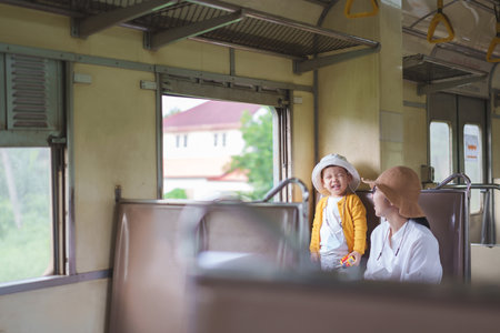 Happy Asian little son and his mother traveling by train, Playful Child with big smile, Laughingの写真素材