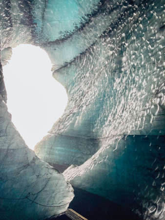 The view out of a glacier cave with ice and ash layers in Icelandの写真素材