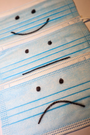 three covid medical face masks with smiling facesの写真素材