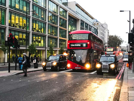 a red double-decker bus and cars in londonの写真素材