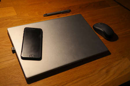 A Smartphone and Laptop on a wooden Table