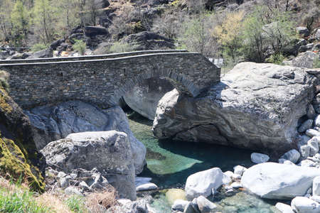 Bavona Valley, Switzerland, 12. April 2022: The Old romain stone bridge over the Bavona River in Ticino, Switzerland.のeditorial素材