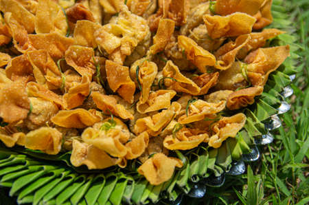 Picture of golden bags on a plate of banana leaves and aluminum in the background meadow - selected focusの写真素材