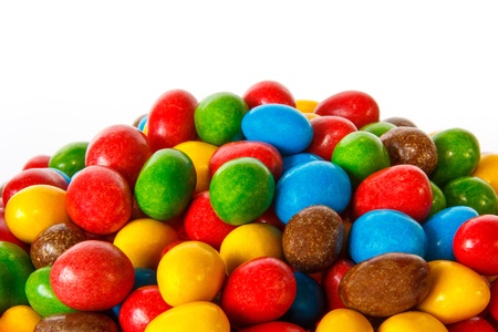 Closeup of a pile of colored chocolate sweets against white backgroundの写真素材
