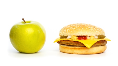 Choosing a healthy apple or an unhealthy burger against a white backgroundの写真素材