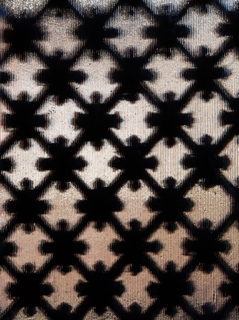 Diamond pattern ironwork with decorations and fluted glassの写真素材