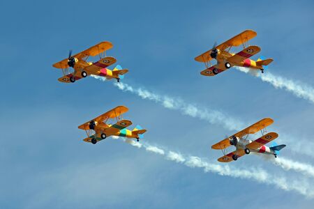 Four Biplanes Flying in Formation with Smokeの写真素材