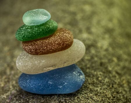 Stack of Five Sea Glass Pebbles in the Sandの写真素材